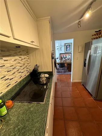 a kitchen with granite countertop a refrigerator and a stove