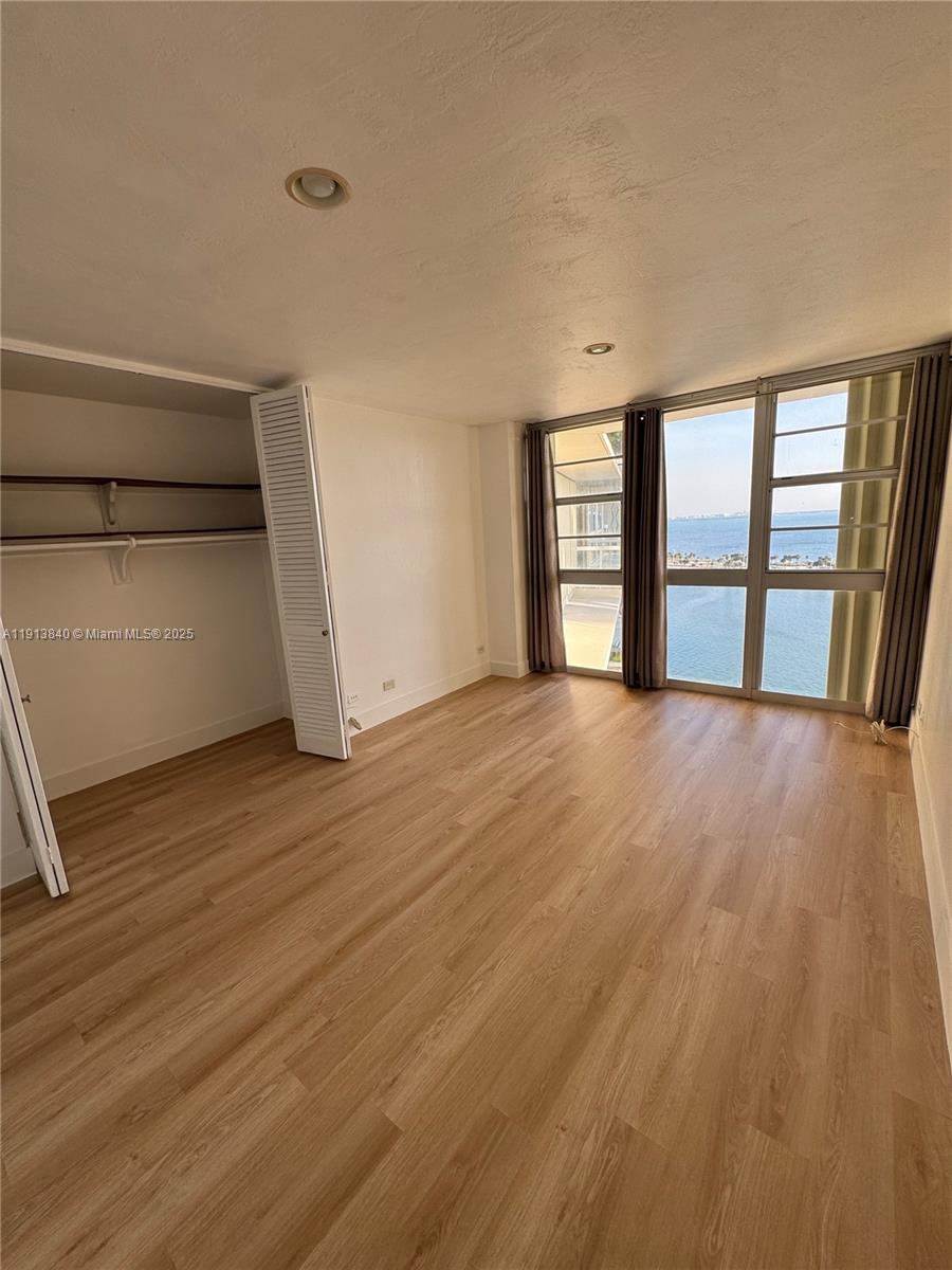 2451 Brickell Avenue, Unit 16U Miami, FL 33129 - Photo 6 of 17 wooden floor in an empty room with a window