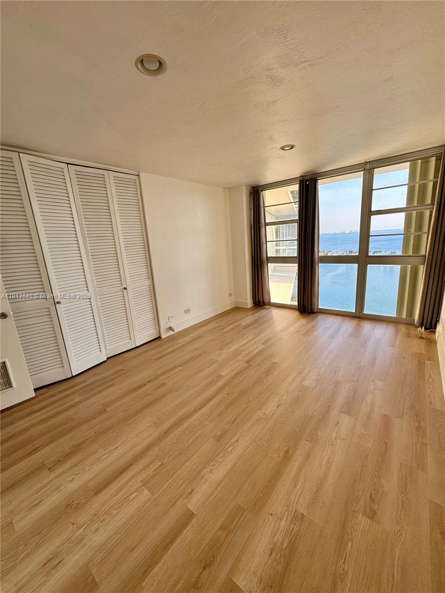 2451 Brickell Avenue, Unit 16U Miami, FL 33129 - Photo 7 of 17 a view of an empty room with a window and wooden floor