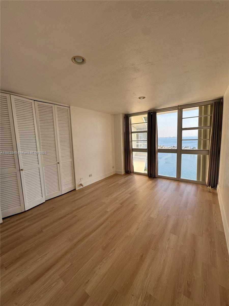 2451 Brickell Avenue, Unit 16U Miami, FL 33129 - Photo 9 of 17 a view of an empty room with a window and wooden floor