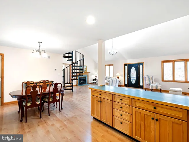 a large living room with stainless steel appliances kitchen island granite countertop furniture and a large window