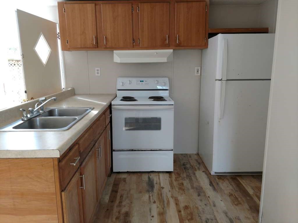 368 Pine Ridge Drive Cleveland, TX 77327 - Photo 6 of 27 a kitchen with a sink a stove and a refrigerator