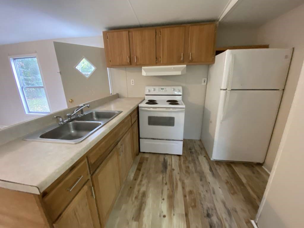 368 Pine Ridge Drive Cleveland, TX 77327 - Photo 7 of 27 a kitchen with a sink a refrigerator and a stove