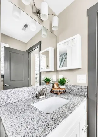 a bathroom with a granite countertop sink and a mirror