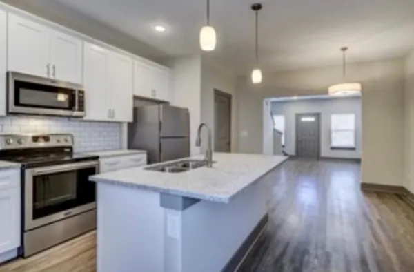 a kitchen with kitchen island a sink stainless steel appliances and cabinets