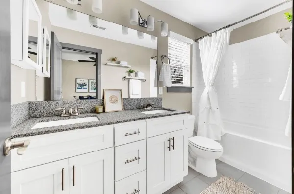 a bathroom with a granite countertop sink a toilet and a bathtub