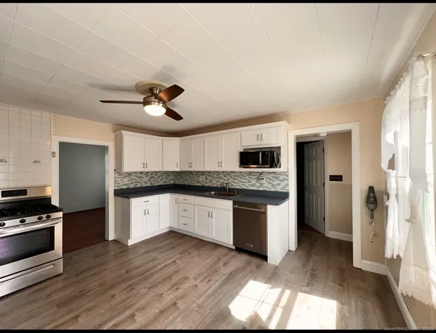 a large kitchen with stainless steel appliances granite countertop a stove and a refrigerator
