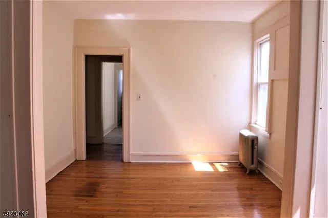 a view of empty room with wooden floor and chair