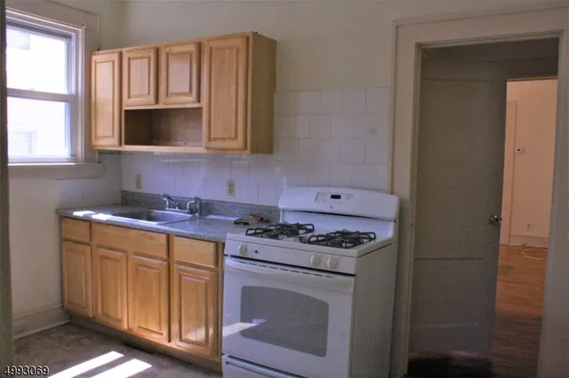 a kitchen with granite countertop cabinets stove top oven and sink