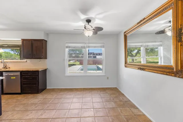 a view of an empty room with a window and cabinet