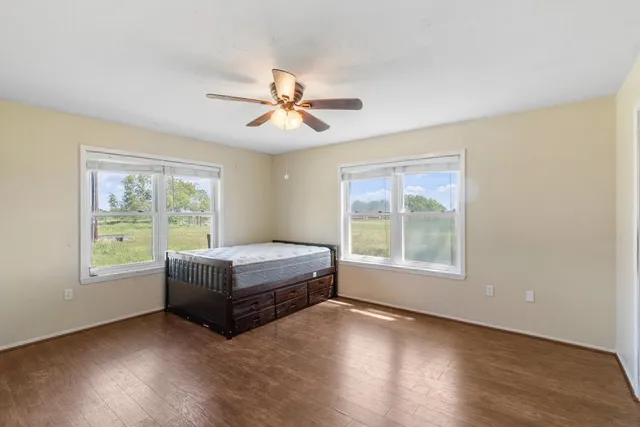 a view of a room with a ceiling fan and a hardwood