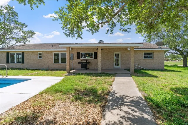 a view of a house with backyard and tree