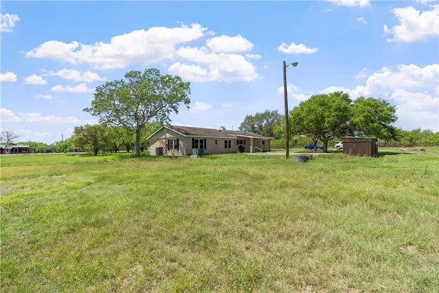 a house view with swimming pool and trees in the background