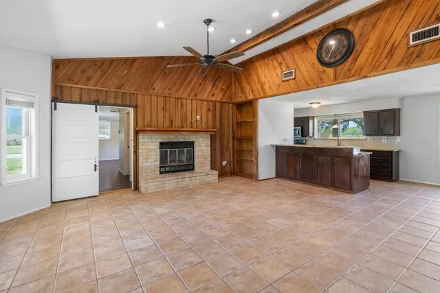 a view of an empty room with window and fireplace