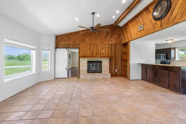a view of an empty room with a fireplace and a window