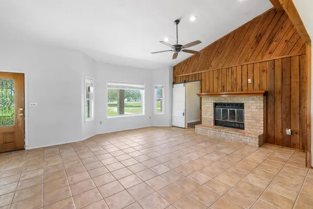 a view of an empty room with a fireplace and a window