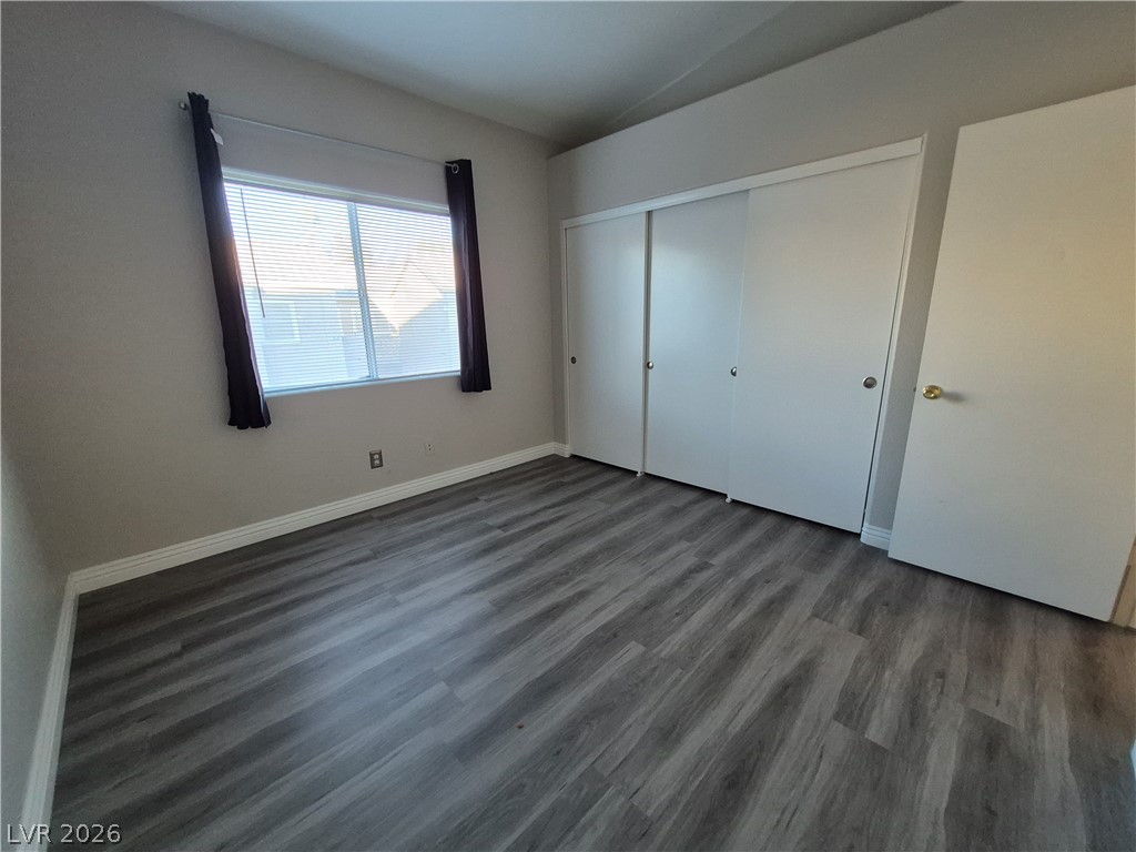 2053 Quarry Ridge Street, Unit 201 Las Vegas, NV 89117 - Photo 4 of 21 Refined wood-look flooring extends throughout this well-appointed bedroom, offering practical elegance and ample storage.