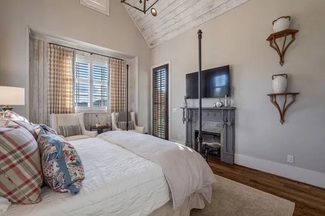 a bedroom with a bed and a flat tv screen on dresser