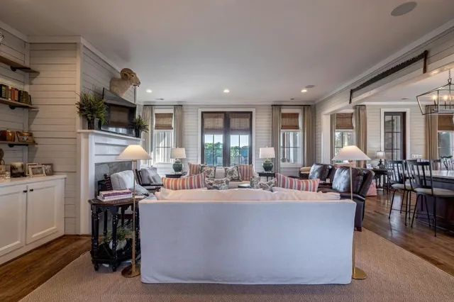 a kitchen with stainless steel appliances kitchen island granite countertop a table chairs in it and wooden floors