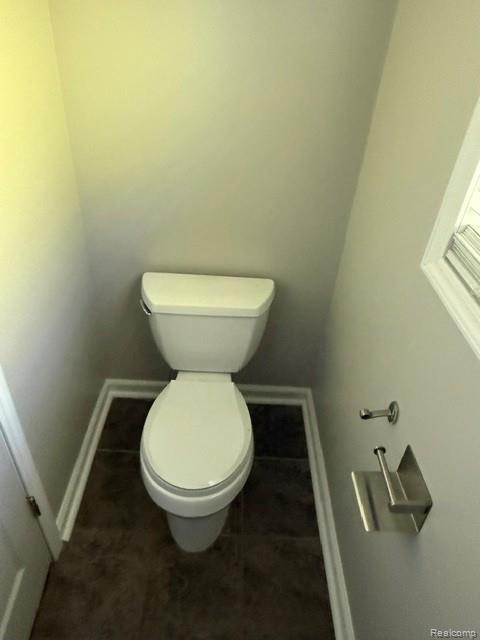 465 Trombley Road Troy, MI 48083 - Photo 21 of 24 White toilet fixture with dark floor tiles and white trim