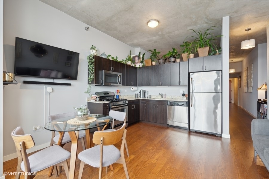 235 West Van Buren Street, Unit 3606 Chicago, IL 60607 - Photo 14 of 27 a kitchen with stainless steel appliances granite countertop a refrigerator a microwave oven a sink a dining table and chairs