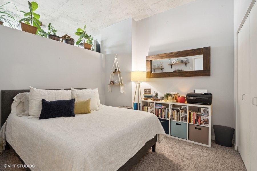 235 West Van Buren Street, Unit 3606 Chicago, IL 60607 - Photo 16 of 27 a bedroom with a bed and a bookshelf