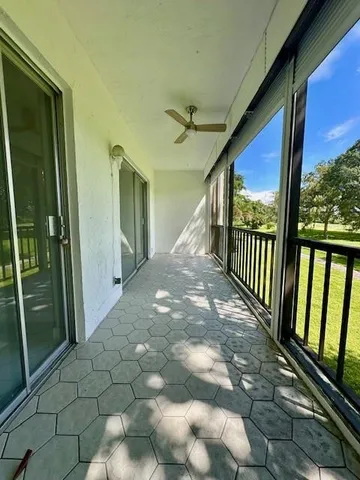 a view of a patio with a table chairs and a small yard