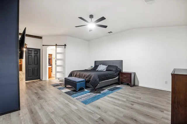 a bedroom with a bed and a ceiling fan