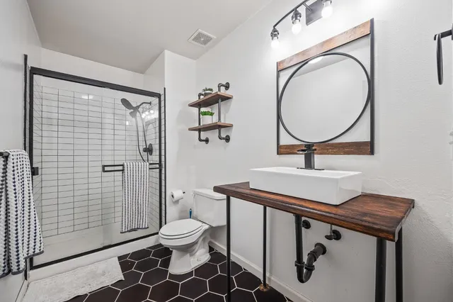 a bathroom with a sink toilet a mirror and shower