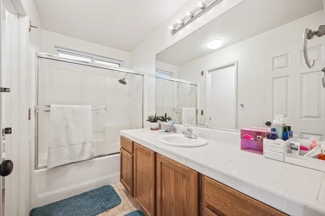 a bathroom with a double vanity sink mirror and shower
