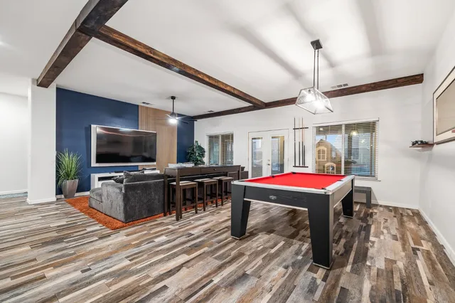 a room with pool table flat screen tv and windows