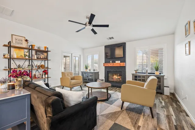 a living room with furniture a fireplace and a flat screen tv