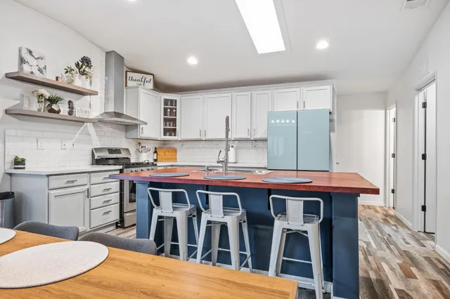 a kitchen with stainless steel appliances granite countertop a stove a sink dishwasher and cabinets with wooden floor