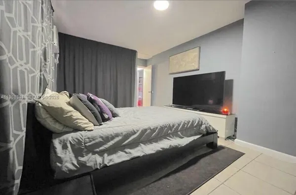 a bed sitting in a bedroom and tv