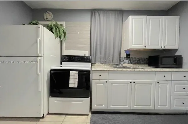 a kitchen with granite countertop white cabinets and stainless steel appliances