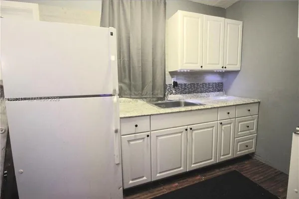 a kitchen with cabinets and a refrigerator