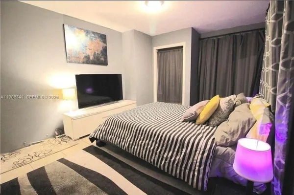 a bedroom with a bed and a painting on the wall