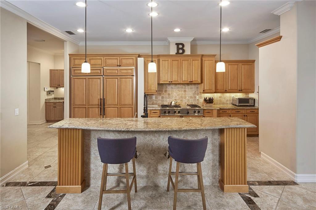 1900 Tiller Terrace Naples, FL 34102 - Photo 13 of 46 a kitchen with kitchen island granite countertop a sink and a refrigerator
