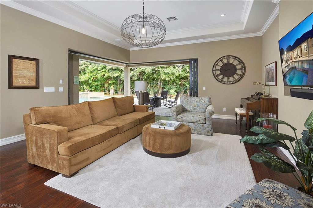 1900 Tiller Terrace Naples, FL 34102 - Photo 16 of 46 a living room with furniture a clock and a large window