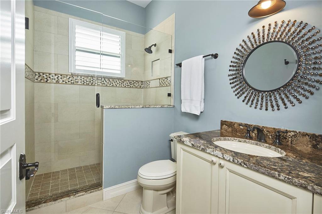 1900 Tiller Terrace Naples, FL 34102 - Photo 18 of 46 a bathroom with a granite countertop sink mirror vanity and toilet