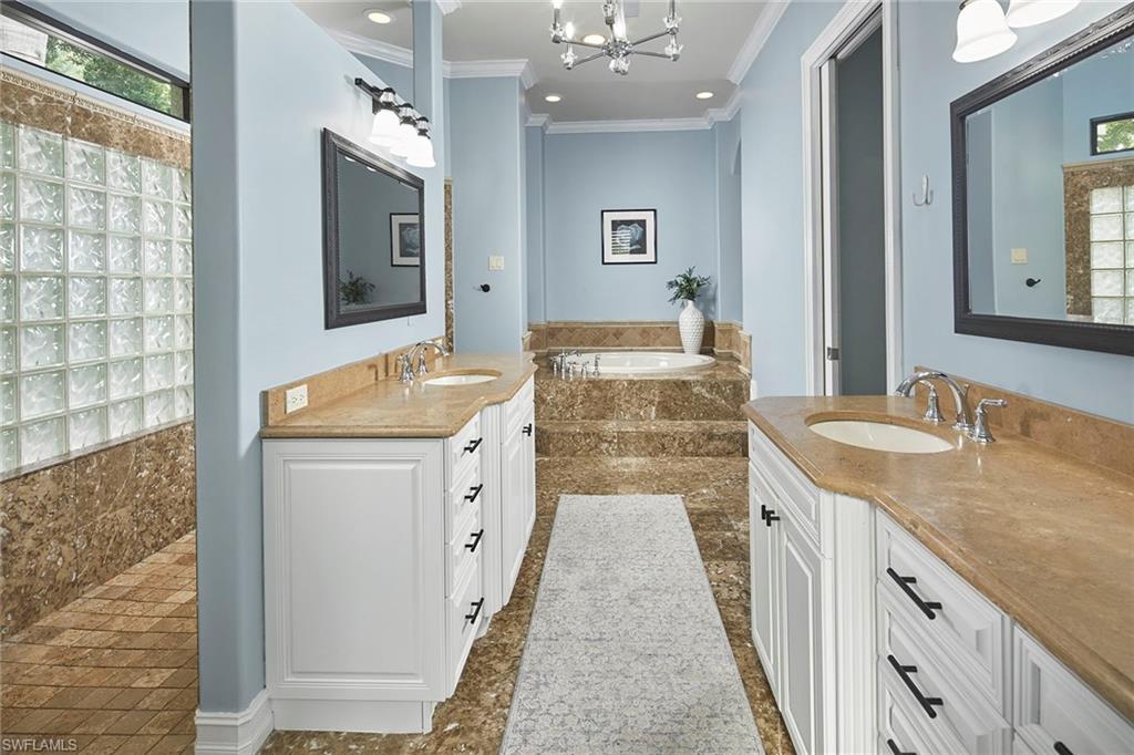 1900 Tiller Terrace Naples, FL 34102 - Photo 22 of 46 a spacious bathroom with a granite countertop sink a mirror a vanity and shower