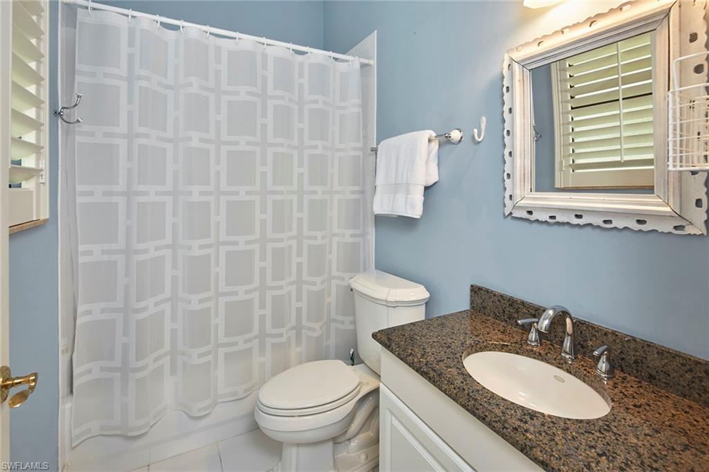 1900 Tiller Terrace Naples, FL 34102 - Photo 28 of 46 a bathroom with a granite countertop sink a toilet and a mirror