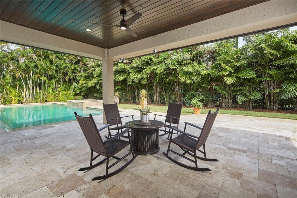 1900 Tiller Terrace Naples, FL 34102 - Photo 29 of 46 a view of a patio with table and chairs and floor to ceiling window