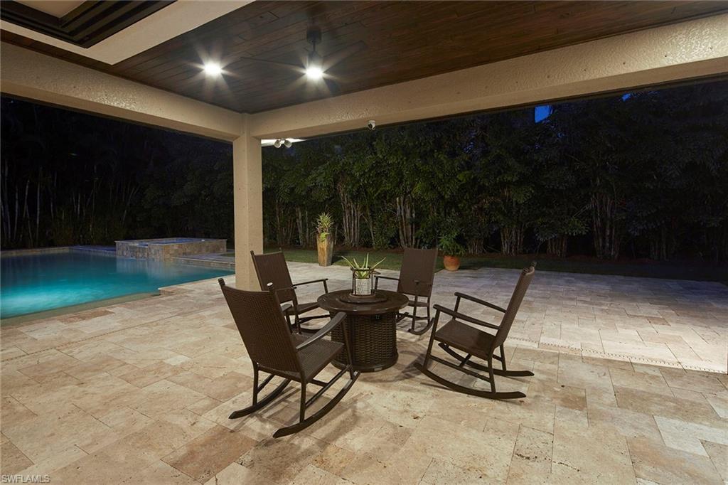 1900 Tiller Terrace Naples, FL 34102 - Photo 30 of 46 a view of a patio with table and chairs with wooden floor and fence