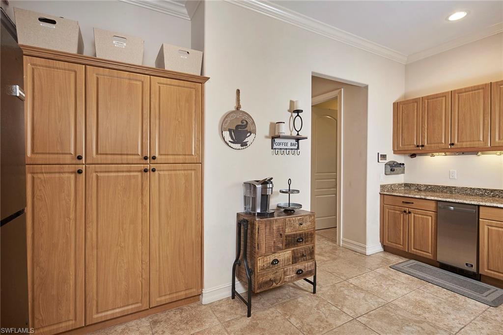 1900 Tiller Terrace Naples, FL 34102 - Photo 36 of 46 a kitchen with granite countertop a refrigerator a sink and white cabinets