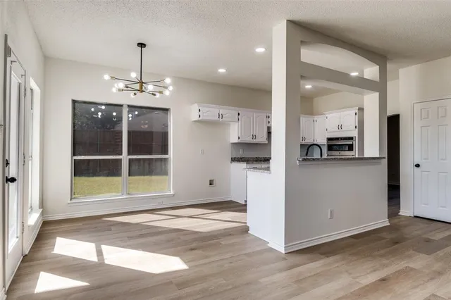 a view of a kitchen with a cabinet and an empty room