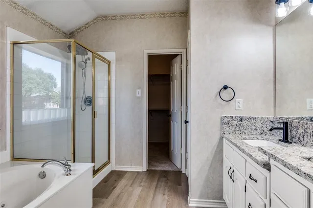 a bathroom with a granite countertop sink mirror vanity and bathtub
