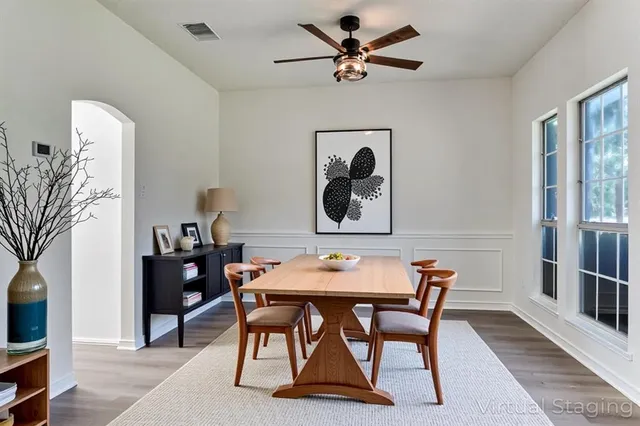 a view of a dining room with furniture and a chandelier fan