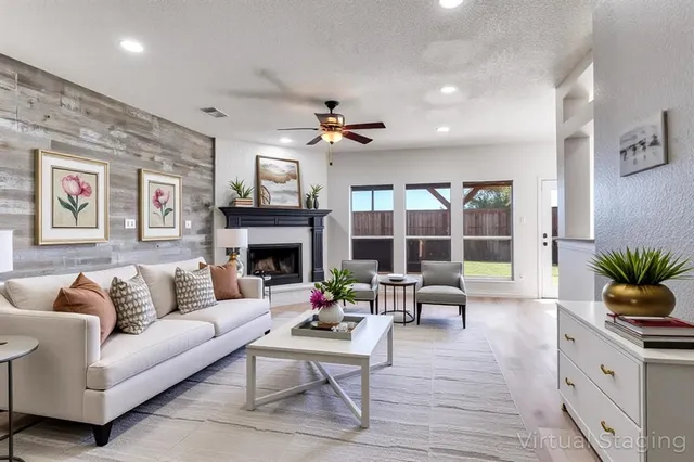 a living room with furniture fireplace and a large window