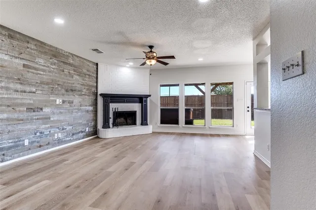 a view of an empty room with a fireplace and a window